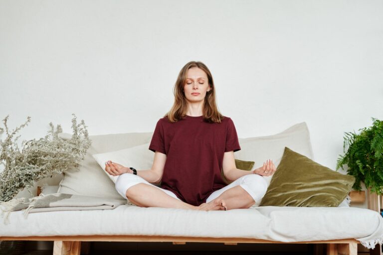 Femme méditant dans un intérieur calme pour apaiser l’anxiété et retrouver la sérénité grâce à l’hypnose